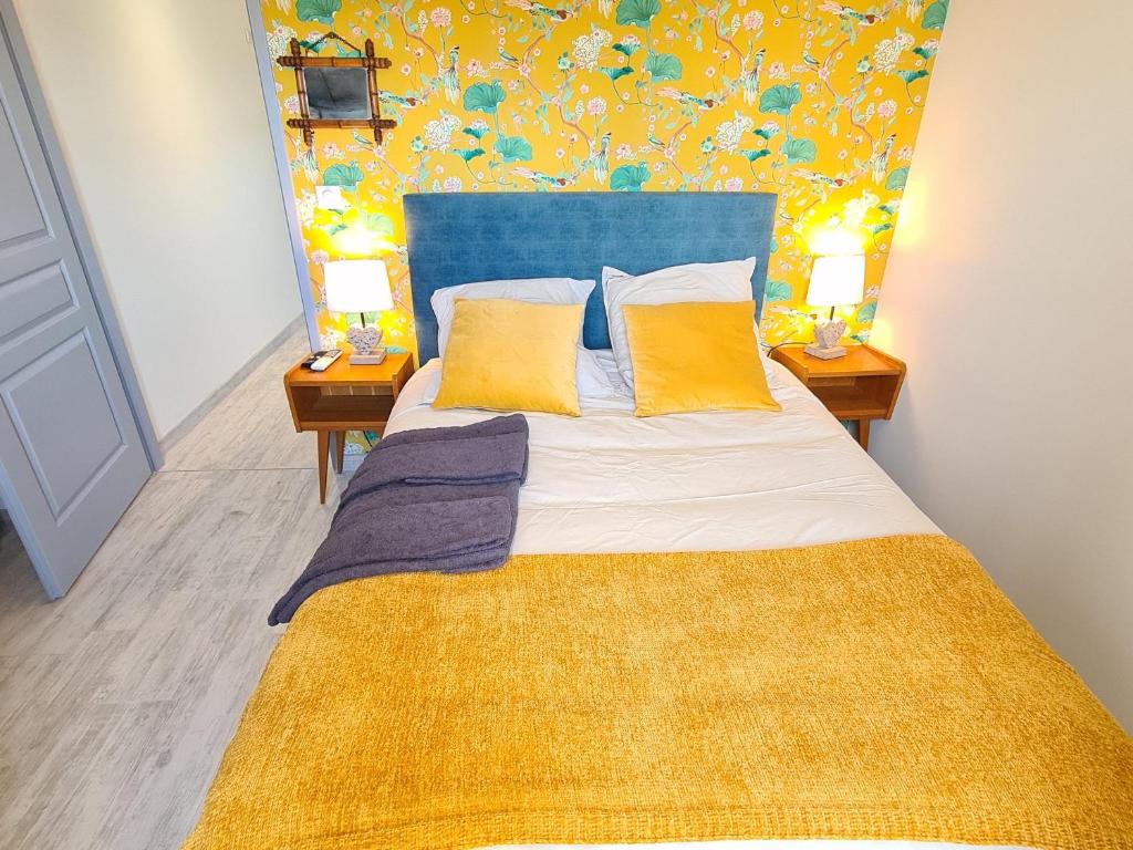 a bedroom with a bed with yellow pillows and two lamps at Guestroom Briare, 1 pièce, 2 personnes - FR-1-590-369 in Briare