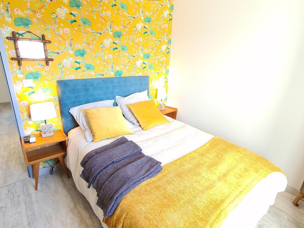 a bedroom with a bed with a blue headboard and a table at Guestroom Briare, 1 pièce, 2 personnes - FR-1-590-369 in Briare