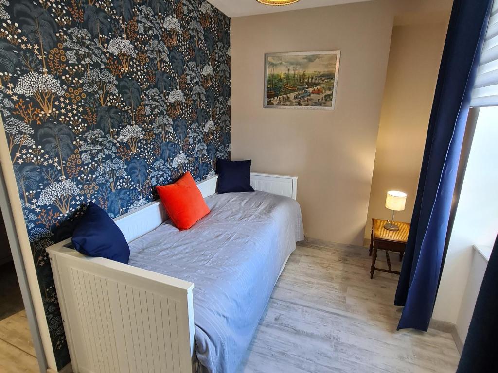 a bedroom with a bed with red and blue pillows at Guestroom Briare, 1 pièce, 2 personnes - FR-1-590-369 in Briare