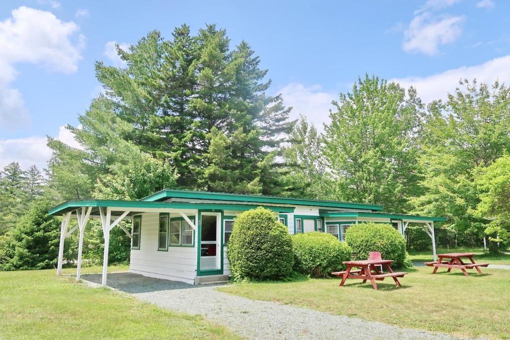 a small cottage with two picnic tables in the grass at PATIO MOTOR COURT in Carroll