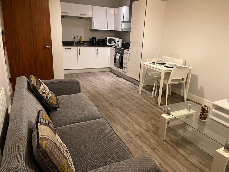 a living room with a couch and a table and a kitchen at Apartment in Central Gillingham in Hoo