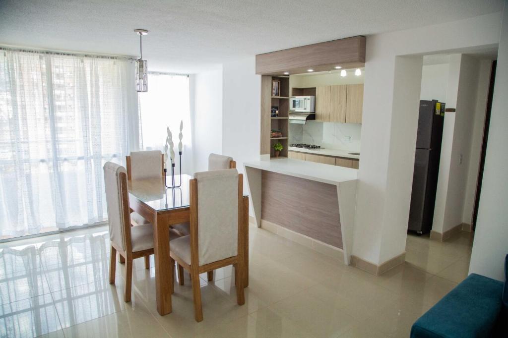 Magnífico Apartamento amoblado Medellín في بيلو: مطبخ وغرفة طعام مع طاولة وكراسي