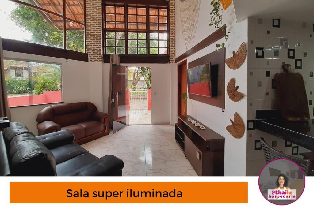 uma sala de estar com um sofá de couro e uma televisão em Casa 5km Praia Coroa Vermelha 1 quarto no Térreo em Santa Cruz Cabrália