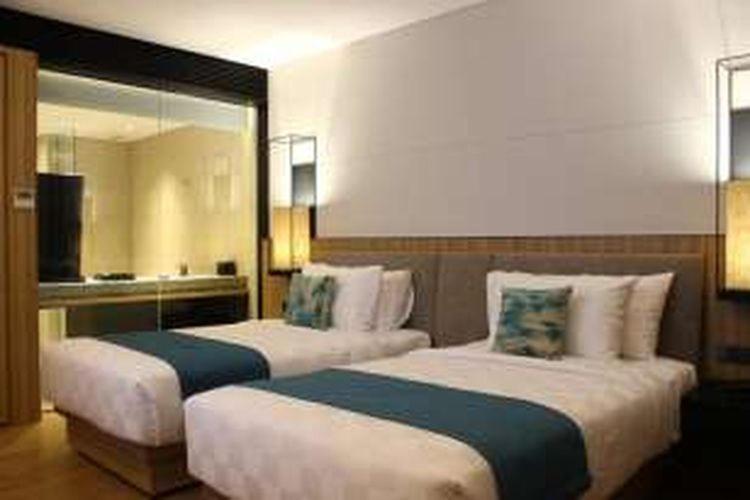 a hotel room with two beds and a mirror at Opitalia Catalia Resort in Jakarta