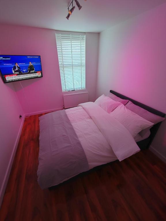 a bedroom with a white bed and a tv on the wall at Magnolia Palazzo in London
