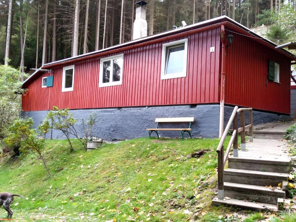 的住宿－Beautiful hut in the Waldstück-Querbachhütte，一间红色和蓝色的房子,前面有长凳