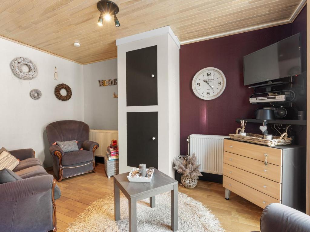 uma sala de estar com um sofá e um relógio na parede em Van Mullemstraat 15 2 bedrooms on floor 2 em Blankenberge