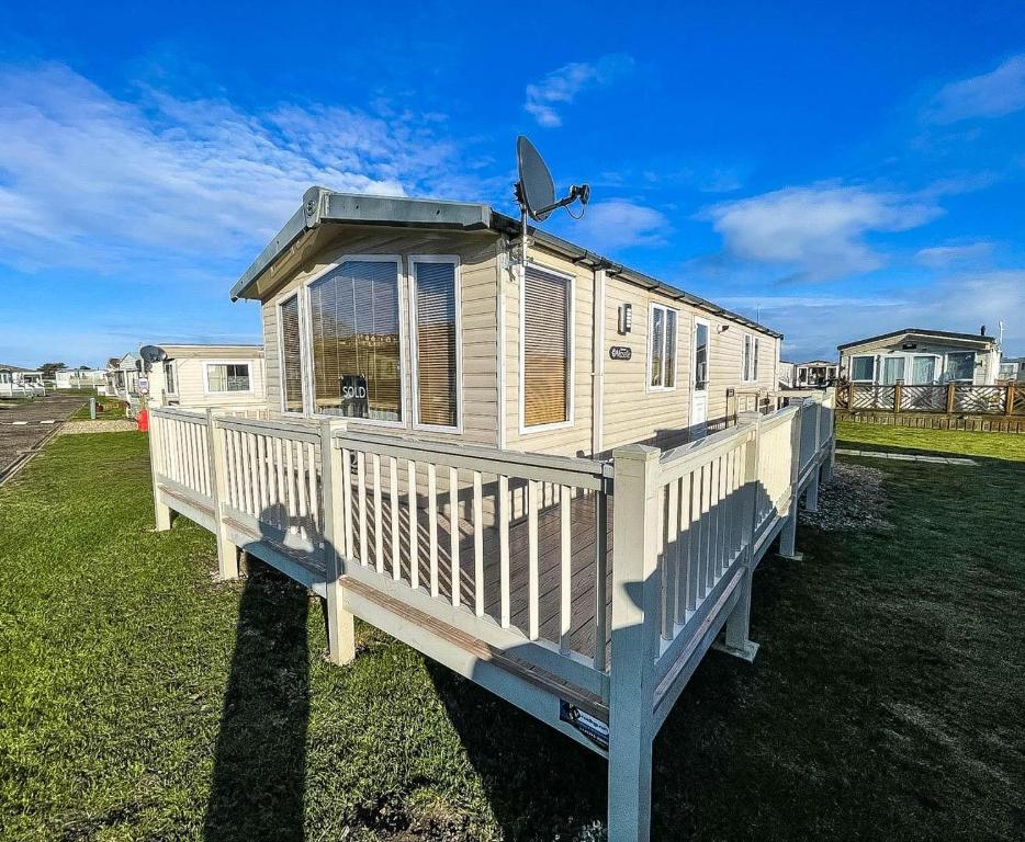 a tiny house with a porch and a solarium at Lovely Caravan With Spacious Decking At North Denes In Suffolk, Ref 40134nd in Lowestoft