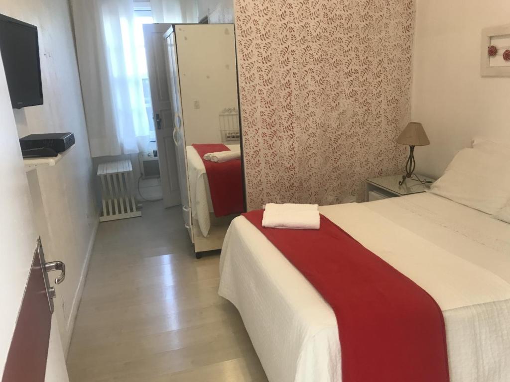 una camera d'albergo con letto e specchio di Hotel pousada porto real a Morretes