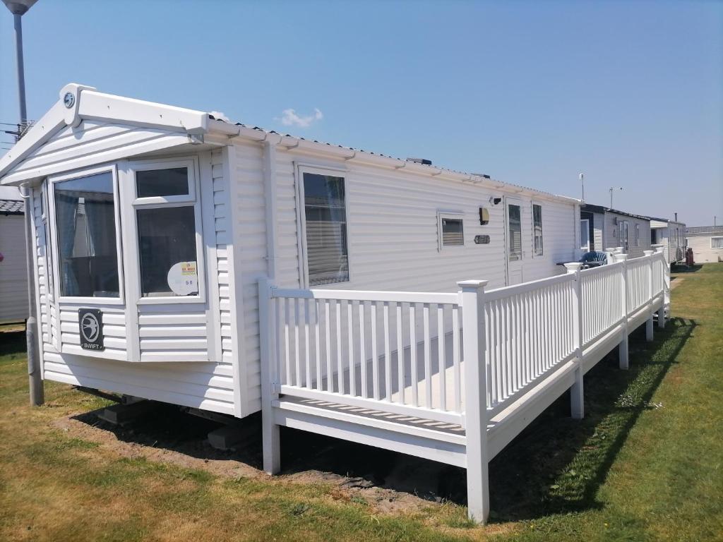a white mobile home with a white fence at Seaside Delight - Close to the beach in Kent