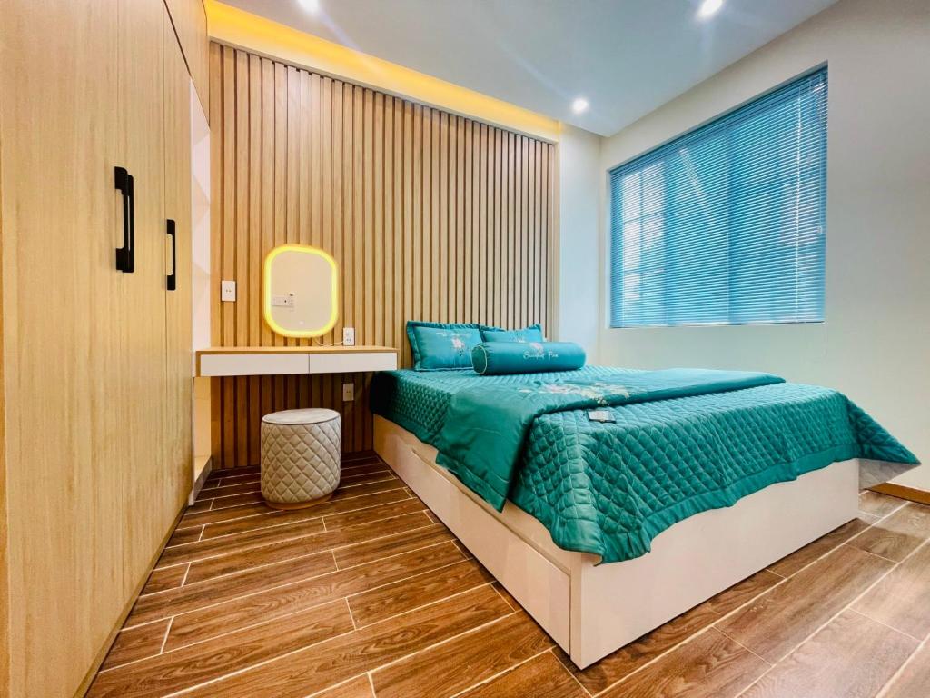 a bedroom with a bed with a green comforter at Ocean Villa Novaworld Phan Thiết in Bình Tú