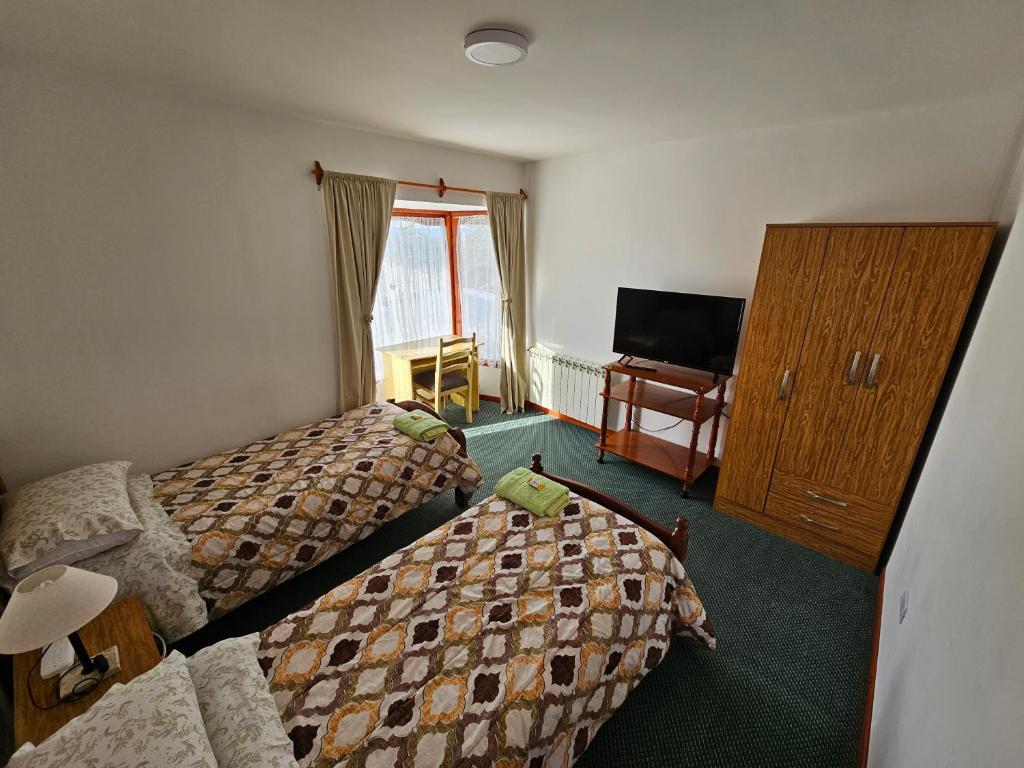 a hotel room with two beds and a television at Casa de familia in Ushuaia