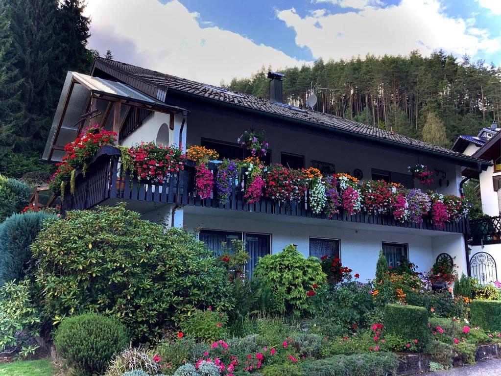 a house with lots of flowers on a balcony at Ferienwohnung Schwarzwälder in Hornberg
