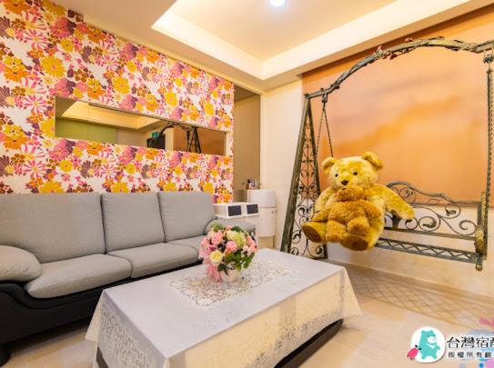 a teddy bear sitting on a swing in a living room at 花蓮幸福約定民宿4-12人包層,一天招待一組朋友,近花蓮市區中心,花蓮遠東百貨,花蓮文創,東大門夜市 in Hualien City