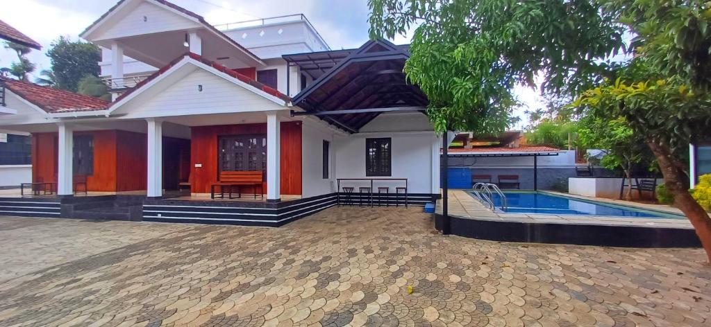 una casa con piscina frente a ella en Empire Pool Villa, en Meenangadi