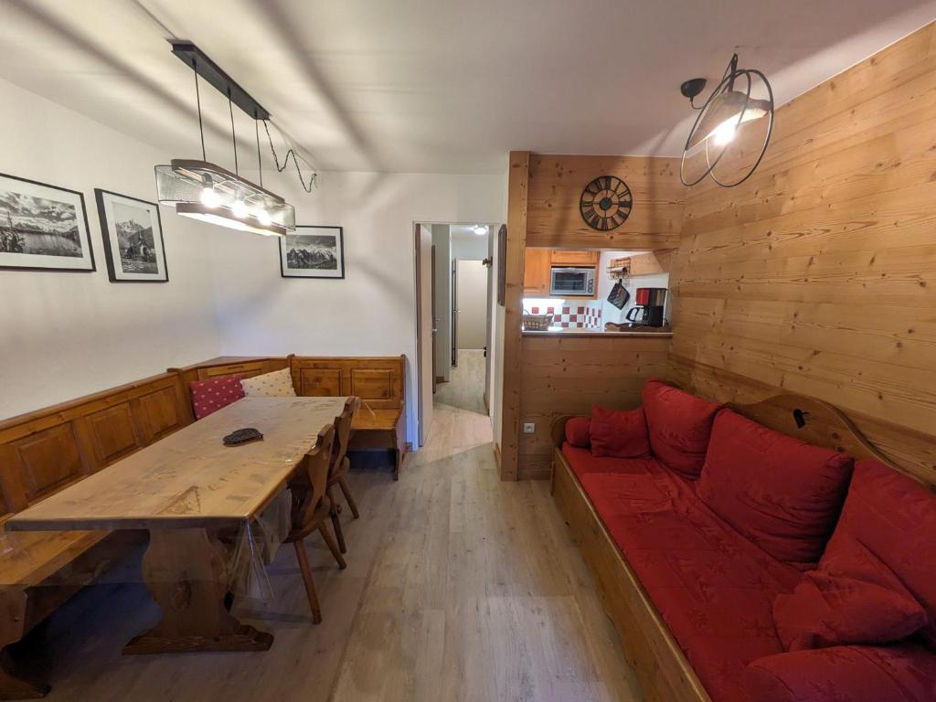 un salon avec un canapé rouge et une table dans l'établissement Charmant 2 pièces pour 4 personnes avec balcon et parking – Chamonix Sud, à 5 min du centre - FR-1-343-250, à Chamonix-Mont-Blanc