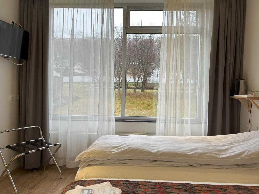 sypialnia z łóżkiem i dużym oknem w obiekcie Hotel Eskifjörður w mieście Eskifjörður