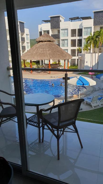 een patio met een tafel en stoelen en een zwembad bij Manzanillo Depto. ¡buena vibra! in Manzanillo