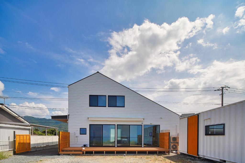 a white house with glass windows on a street at BHOLIC（ビーホリック） in Shimonoseki