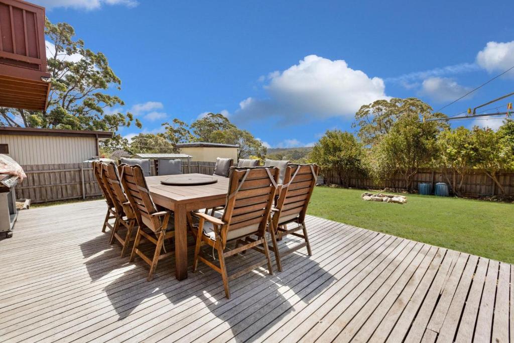 una mesa de madera y sillas en una terraza de madera en Harmony, en Lakes Entrance