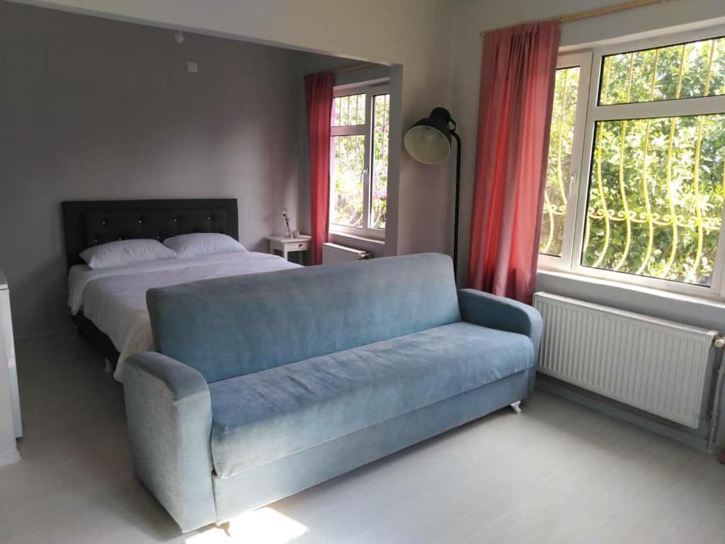 a bedroom with a bed and a blue couch at RAZI TURIZM in Istanbul