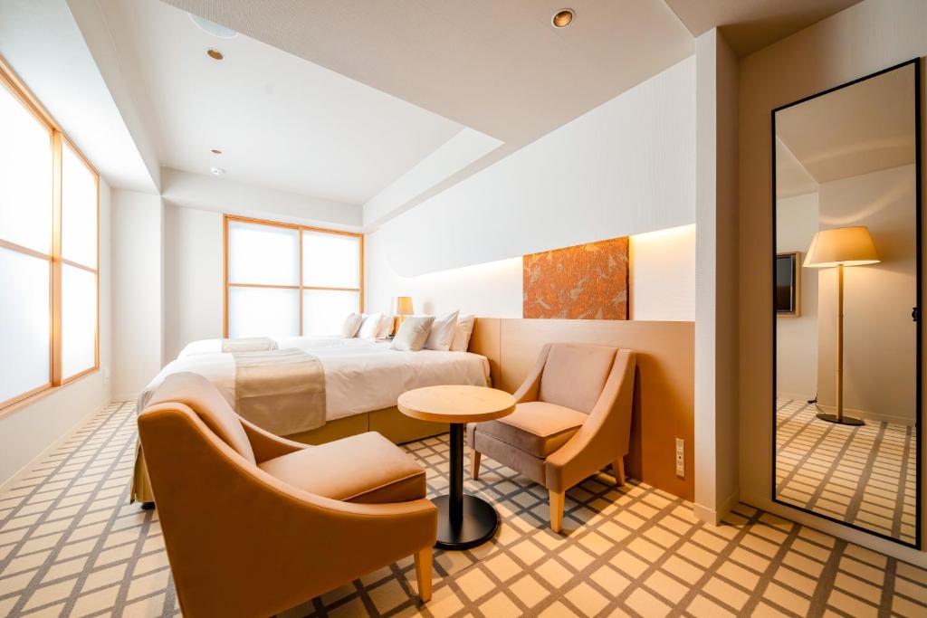 um quarto de hotel com uma cama, uma mesa e cadeiras em THE GENERAL KYOTO Shijou Shinmachi em Quioto