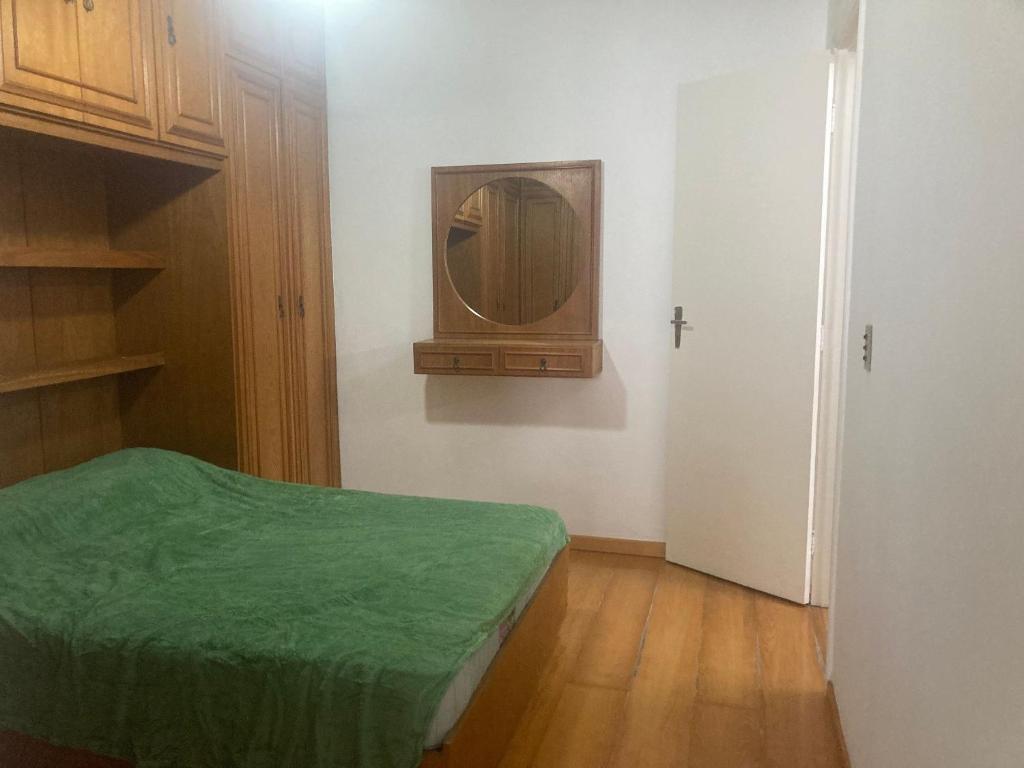 una camera con un letto e uno specchio a parete di Apartamento no Hotel Quitandinha 40 a Petrópolis