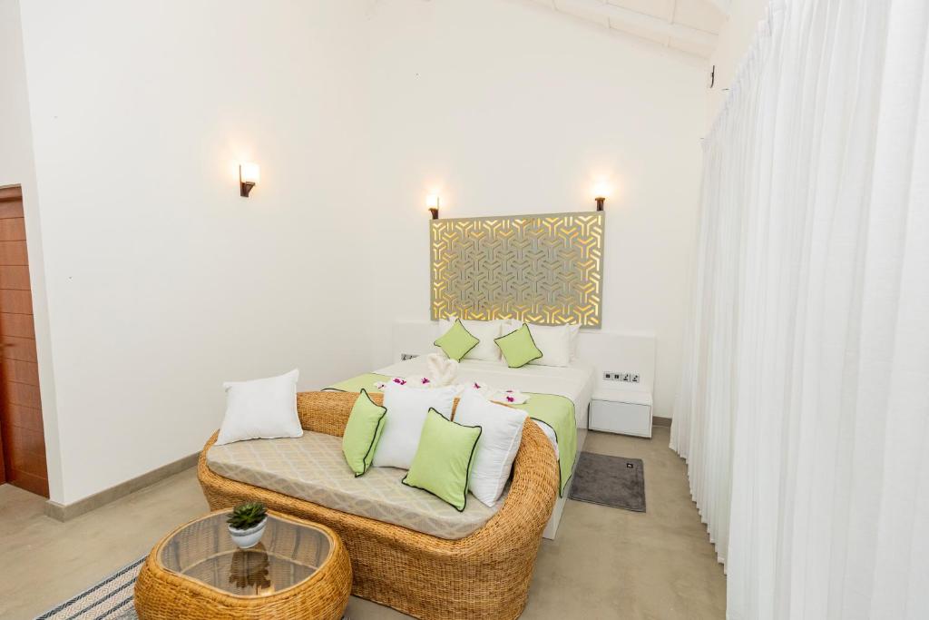 a white room with a bed and a couch at The Dahlia Residence in Bentota
