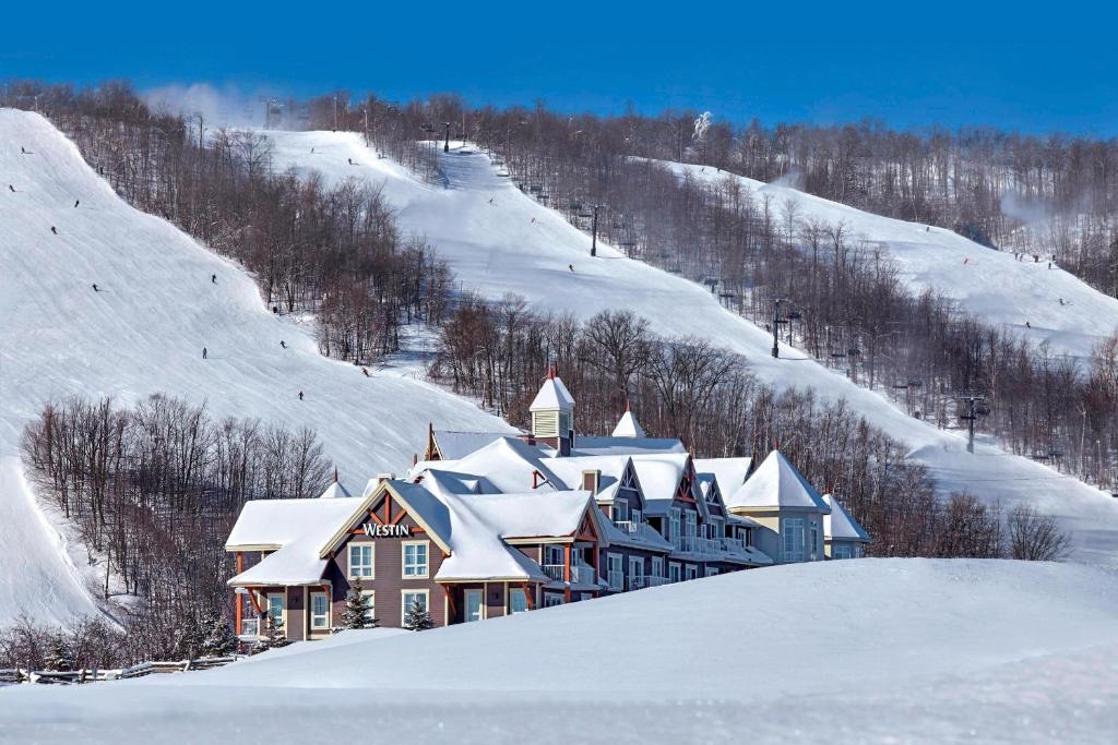 una casa en una colina nevada con nieve en The Westin Trillium House, Blue Mountain en Blue Mountains