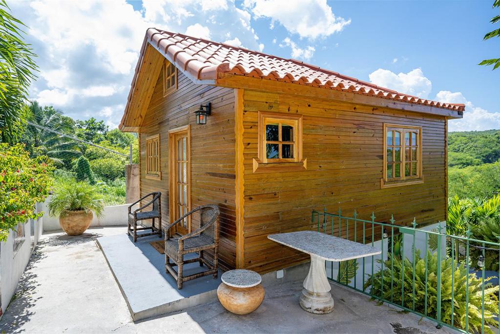 ein kleines Holzhaus mit einer Bank auf einer Terrasse in der Unterkunft Private Tiny House w/ Pool in Montego Bay