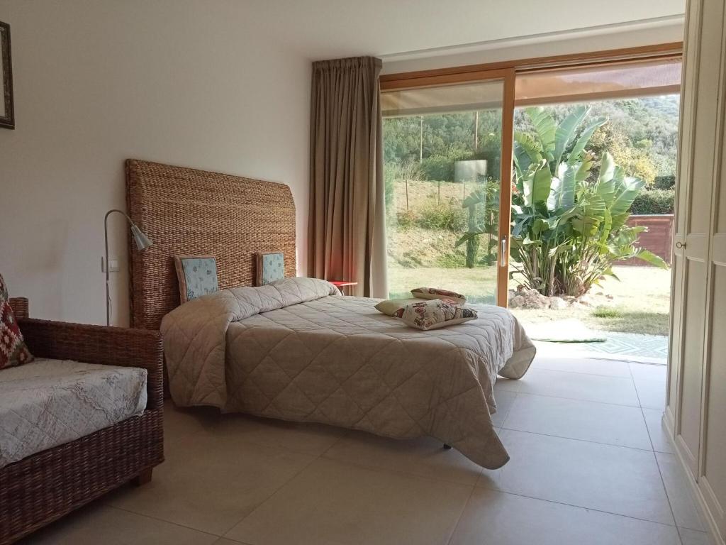 een slaapkamer met 2 bedden en een groot raam bij Holiday home Biocasa Fabiana, Portoferraio Magazzini in Magazzini