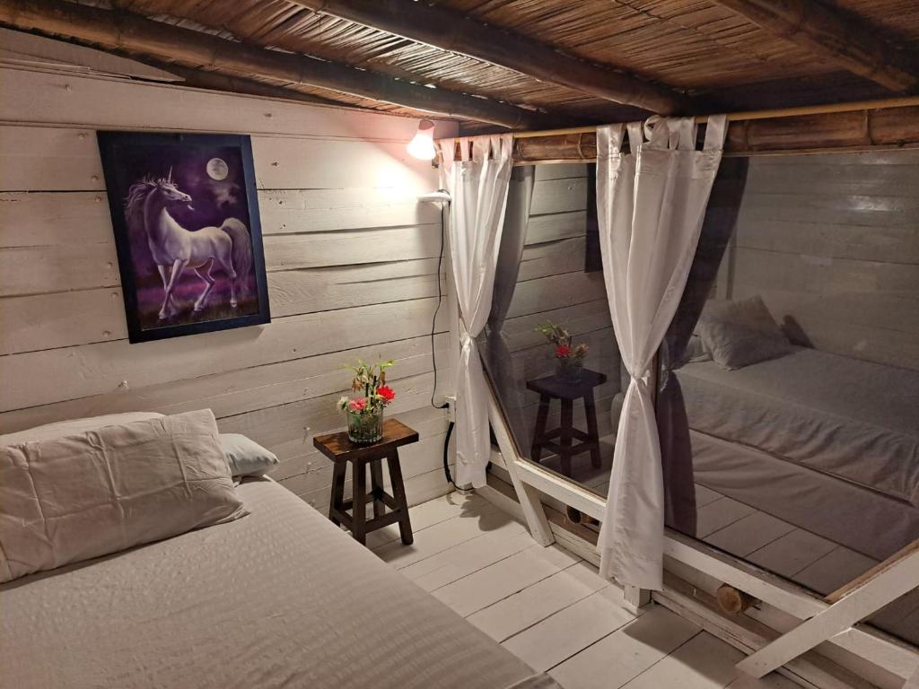 - une chambre avec un lit et une fenêtre ornée d'une peinture à cheval dans l'établissement Hotel Gabarra Lodge, à San Vicente