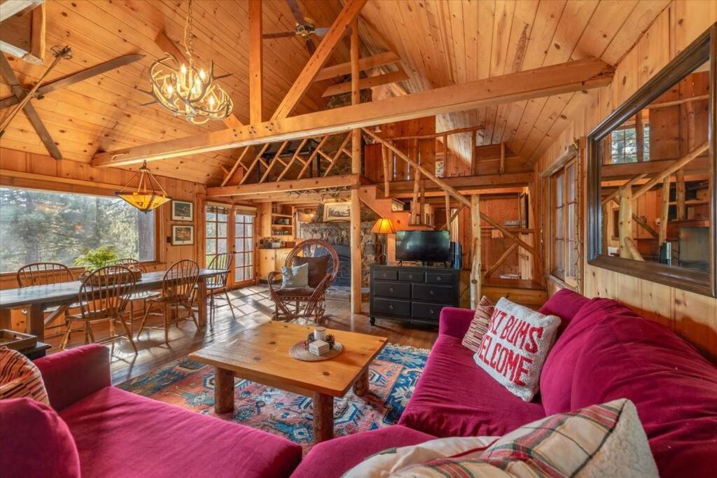 a living room with a purple couch and a table at Coziest Cabin in Tahoe w Stone Fireplace Comfy Beds Close to Slopes & Lake in Carnelian Bay