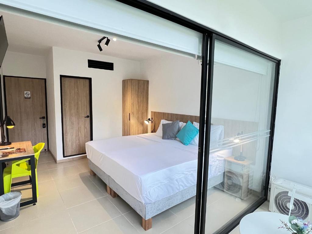 a bedroom with a bed and a glass wall at HOTEL 9.5 SAN FERNANDO in Cali