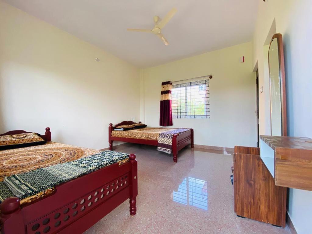 - une chambre avec 2 lits et une fenêtre dans l'établissement MISTY COORG GREENS, à Madikeri