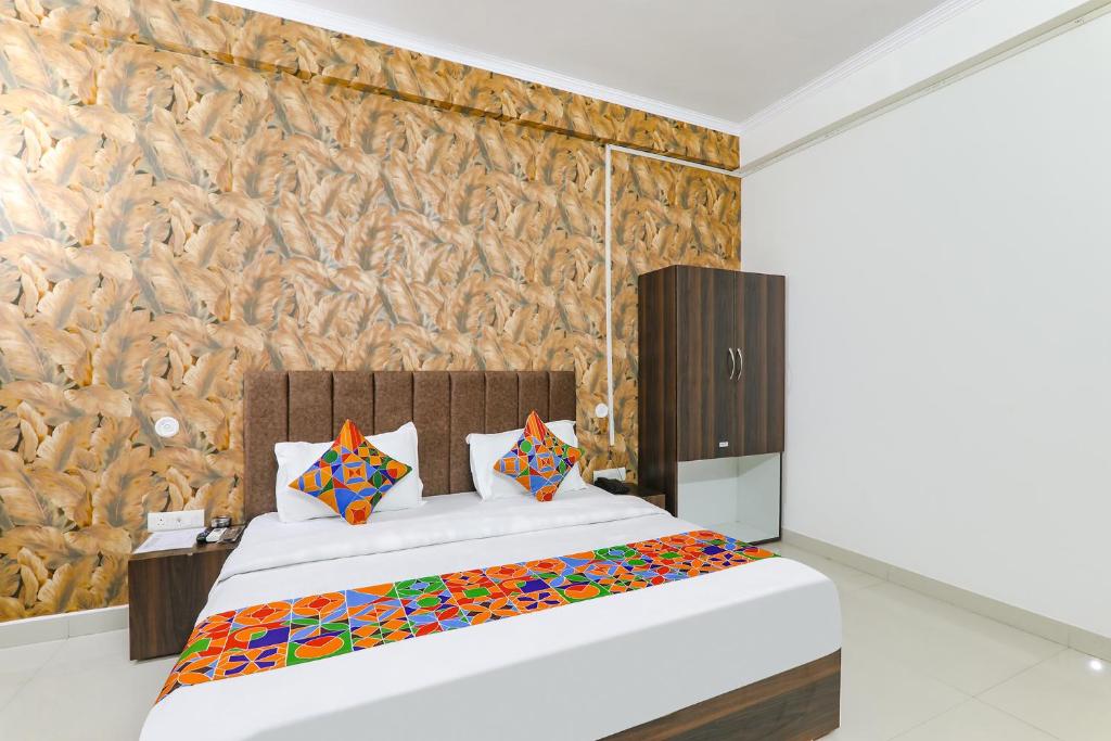Un dormitorio con una cama grande y una pared en FabHotel The Villa I, en Prayagraj