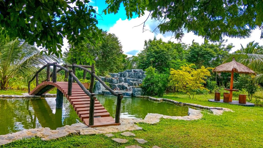 - une aire de jeux dans un parc avec un pont sur un étang dans l'établissement Ceylon Amigos Eco Resort, à Sigirîya