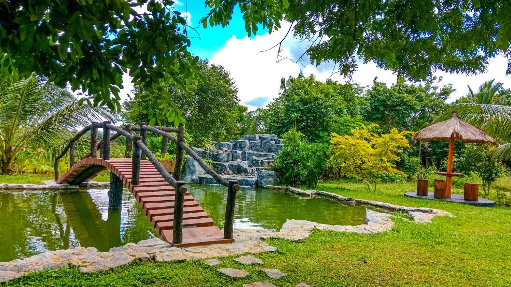 a playground in a park with a bridge over a pond at Ceylon Amigos Eco Resort in Sigiriya