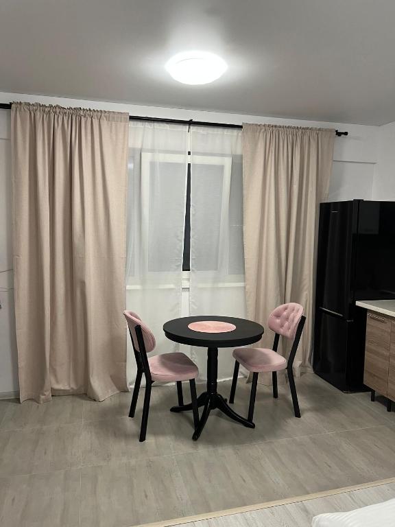 a room with a table and two pink chairs at Pollux Residence Militari ap 158 in Dudu