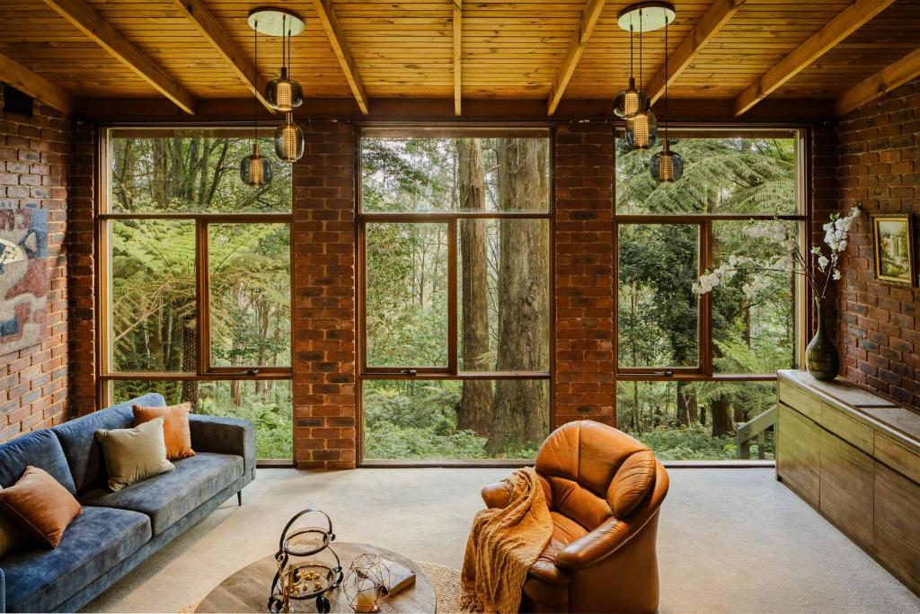 an open living room with a brick wall at Modern Seednest Treehouse, Forest & Mountain View in Sassafras
