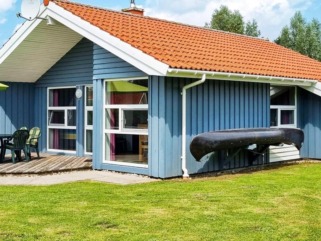 Una casa azul con un gran cañón a un lado. en 6 person holiday home in Otterndorf, en Otterndorf
