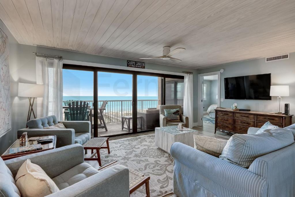 a living room with couches and a view of the ocean at Amelia The Sea - 442 ASea in Fernandina Beach