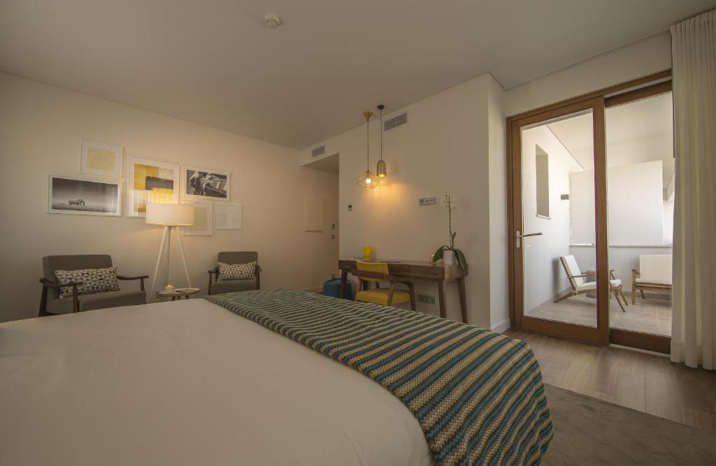 a bedroom with a large white bed and a window at Somewhere - Estoril Guesthouse in Estoril