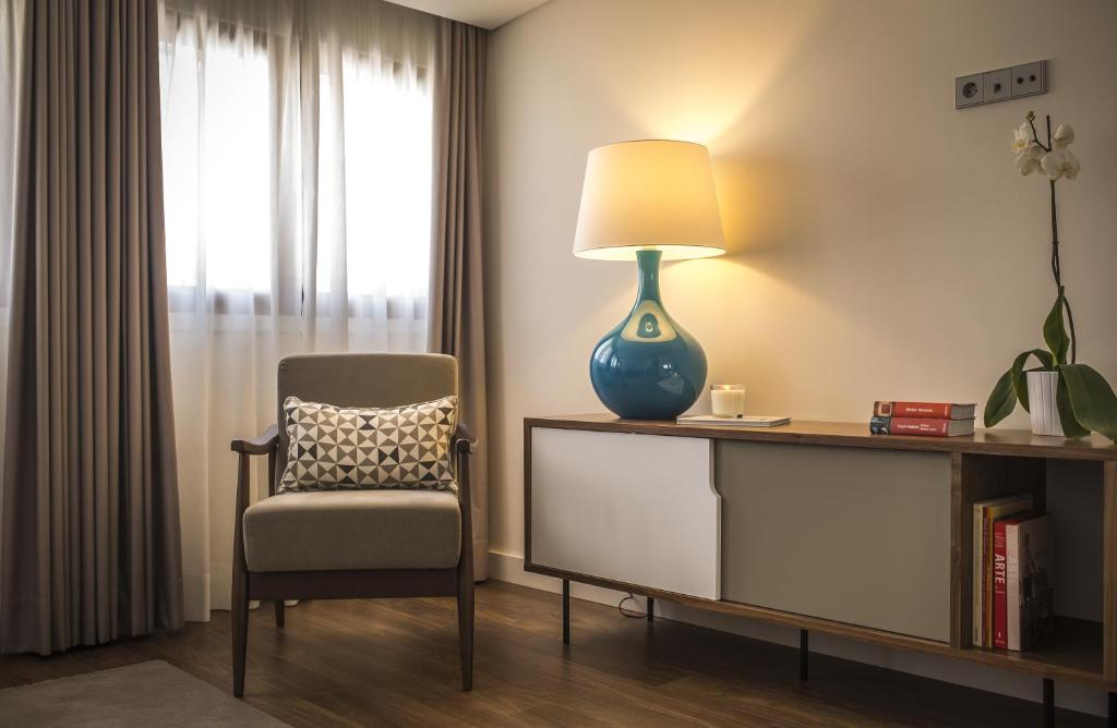 a room with a chair and a lamp on a desk at Somewhere - Estoril Guesthouse in Estoril