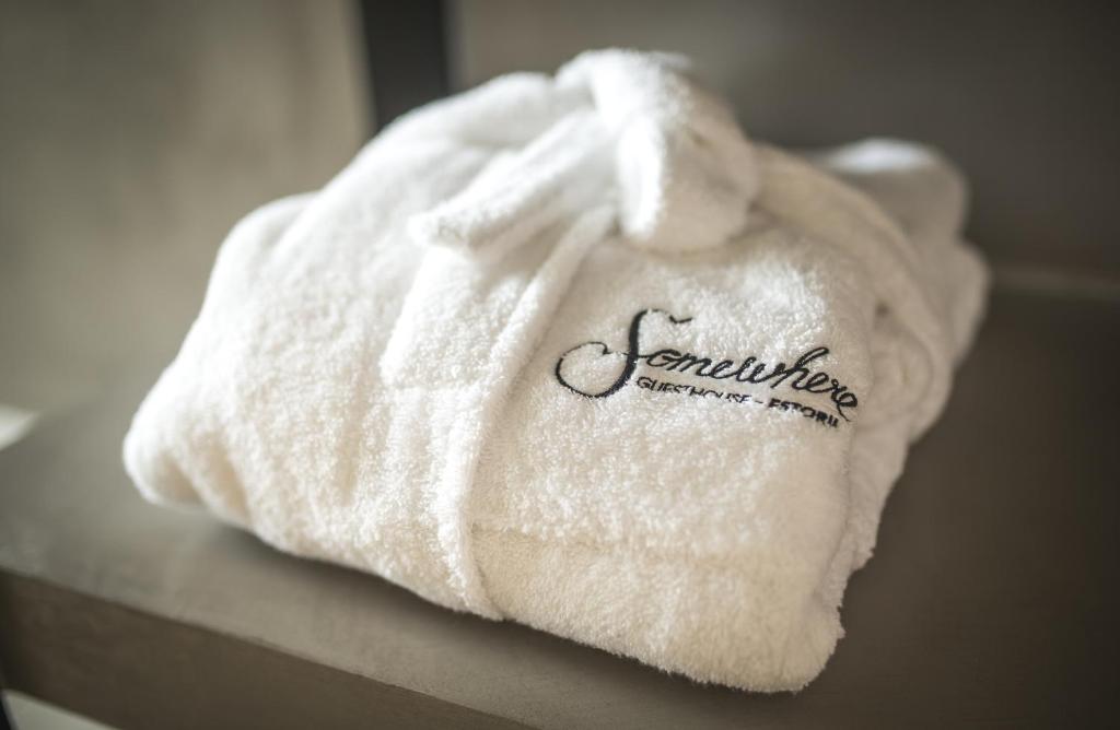 a white towel with the word earthquakechange written on it at Somewhere - Estoril Guesthouse in Estoril
