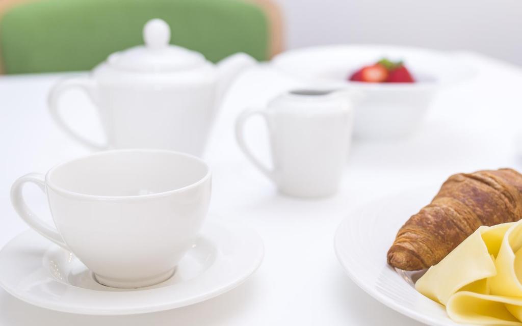 a cup of tea and a plate of food at Somewhere - Estoril Guesthouse in Estoril