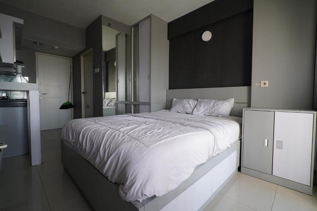 una camera con un grande letto e una cucina di OYO 93366 Apartement Grand Sentraland By Rai Property a Jaken 1