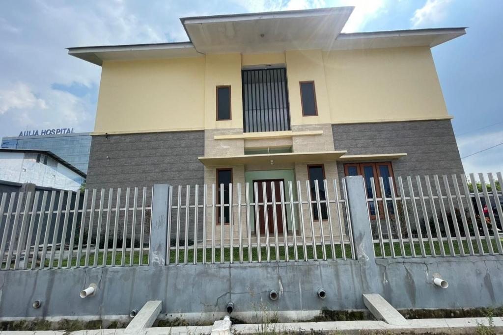 uma casa com uma cerca em frente em SPOT ON 93378 Lona Guest House Syariah em Parit