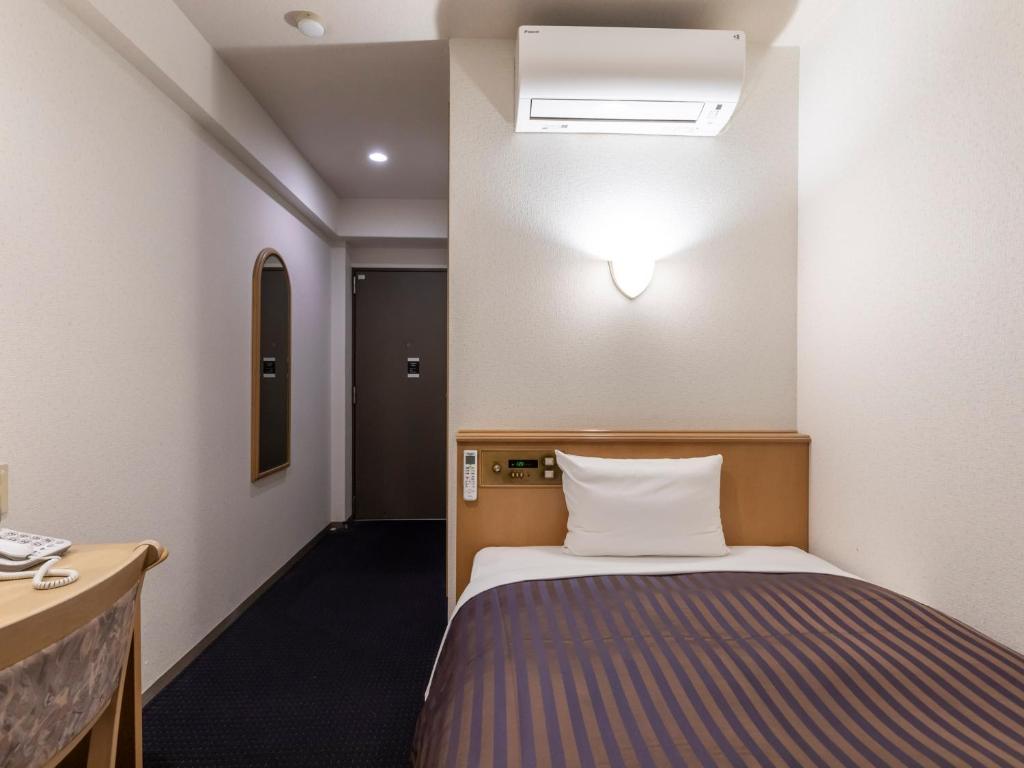 Postel nebo postele na pokoji v ubytování Hotel HORAIRE Saijo