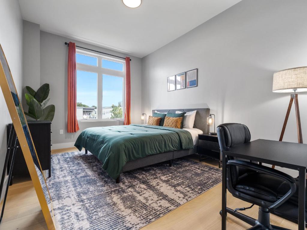 a bedroom with a bed and a desk and a window at Stunning 2BR Condo in Assembly Square East Somerville in Somerville